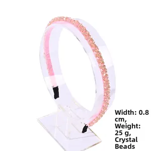 Detail shot of pink crystal headband showing 0.8cm width and 25g weight on a stand