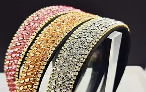 Close-up of sparkling rhinestone headbands in pink, champagne gold, and silver white