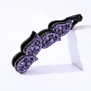 Vue détaillée d'une pince à cheveux banane ornée de strass violets et design vertical
