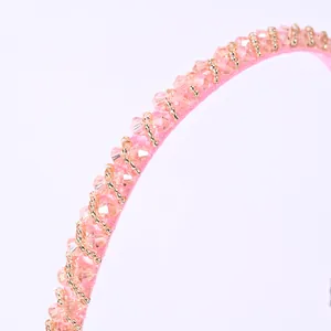 Detalle de diadema de satén rosa con cristales de champán y cuentas doradas cosidas a mano
