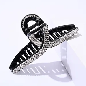 Elegant large black hair claw clip with cross-over design and sparkling white rhinestones