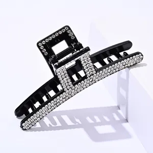 Detail of elegant black hair claw clip with multiple rows of sparkling rhinestones