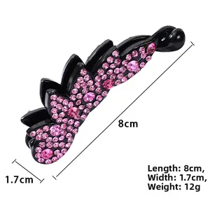 Detail view of 8cm banana hair clip with pink rhinestones on black resin base
