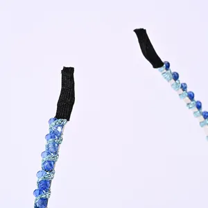 Detalle de diadema vintage con cuentas de cristal azul sobre fino hilo de metal plateado