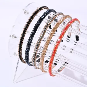 Detail view of five crystal beaded headbands in various colors on a clear display stand