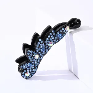 Detail view of wave-shaped banana hair clip with dark blue and iridescent rhinestones