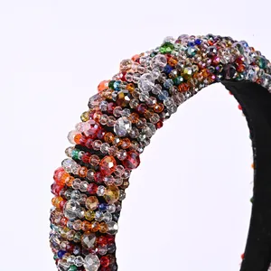 Macro shot of wide padded headband with multi-colored faceted crystals on black fabric