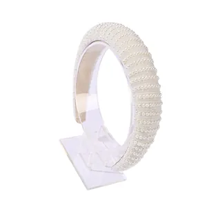 Elegante brede parel haarband voor dames in retro witte stijl op een displaystandaard