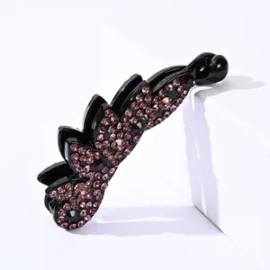 Detail of banana hair clip with pink and purple rhinestones on black resin body