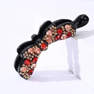 Elegante fermaglio a farfalla con strass rossi e color champagne brillanti