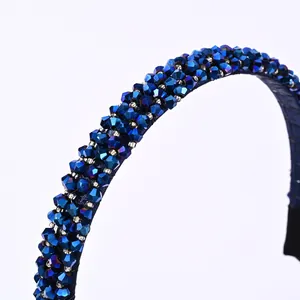 Close-up of a blue crystal beaded headband with faceted glass beads on a fabric base