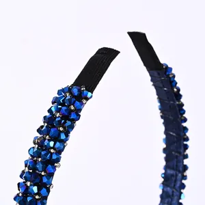 Macro detail of hand-beaded navy crystal headband with secure black fabric end tips