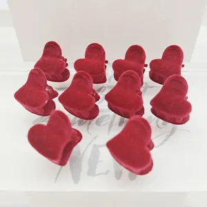 Detalle de diez mini pinzas de pelo con forma de corazón aterciopelado color granate