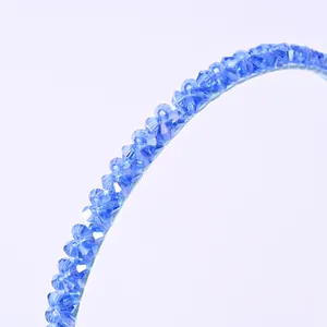 Detalle de diadema de cuentas de cristal azul con montura de tela azul claro a juego