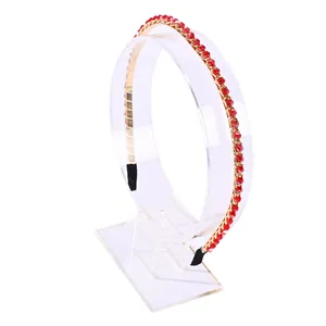 Elegante gouden metalen haarband met fonkelende rode kristallen op een witte achtergrond