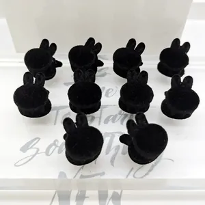 Detalle de diez mini pinzas para el cabello flocadas negras con forma de conejo en soporte