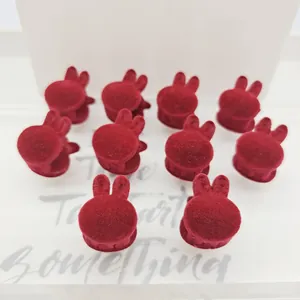 Primer plano de diez mini pinzas para el cabello de conejo flocado rojo con textura