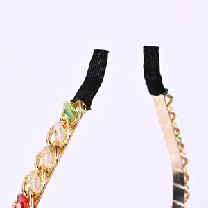 Détail d'un serre-tête en métal doré avec perles en cristal colorées et embouts noirs