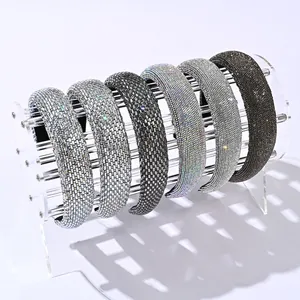 Détail de six serre-têtes rembourrés avec strass étincelants sur un support transparent