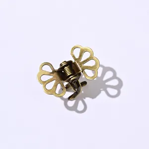 Macro shot of vintage bronze butterfly hair claw clip with detailed hollow petal pattern