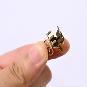 Close-up of a vintage mini bronze metal hair claw with hollow floral design