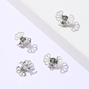 Macro shot of silver hollow butterfly mini hair claws with metal springs on white surface