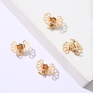 Set of 4 small hollow metal hair claws in polished gold finish on white stone stand