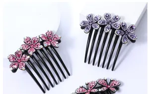 Detailweergave van zeven-tands haarkam met roze en paarse strass steentjes bloemen
