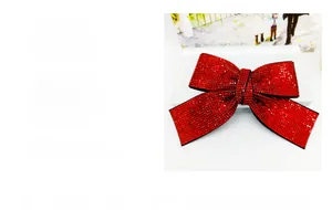 Détail macro d'une grande pince à cheveux nœud rouge ornée de strass brillants et cristaux