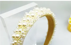 Primer plano de diadema nupcial artesanal con perlas de color crema y acolchado suave
