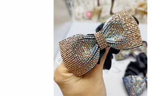 Dettaglio di elastico per capelli in tessuto nero con fiocco di cristalli colorati
