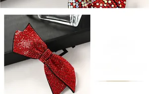 Détail macro des strass rouges sur la pince à cheveux en forme de nœud métallique