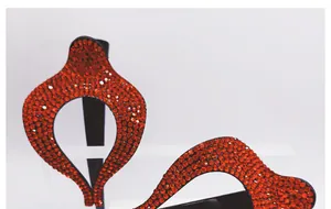 Détail des strass rouges sur une barrette nœud noir avec un design en goutte d'eau ajouré