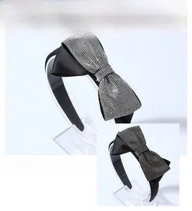 Detail of elegant black satin headband featuring a luxury bow encrusted with silver rhinestones