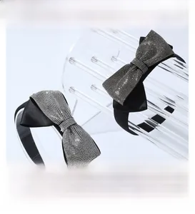 Close-up of sparkling rhinestone bow headband with black satin and high-density crystals