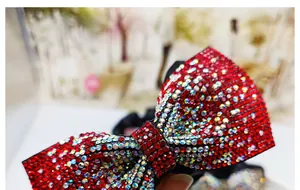 Vista macro di strass rossi e bianchi scintillanti su un elastico per capelli a fiocco