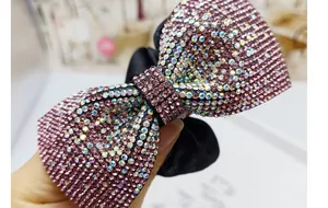 Dettaglio di strass colorati scintillanti su un elastico in velluto nero a fiocco