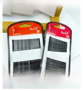 Detail view of black metal hair clips set with straight and wavy styles in paper card packing