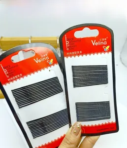 Close-up of black metal bobby pins set in professional red and white packaging cards
