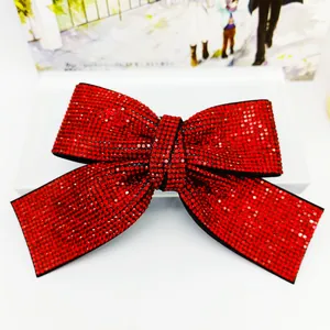 Barrette nœud rouge élégante ornée de strass brillants sur un fond blanc pur