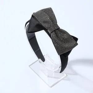 Sparkling rhinestone bow headband in black satin fabric for elegant hair styling