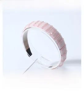 Detail view of light pink beaded headband with textured ridges and soft inner lining