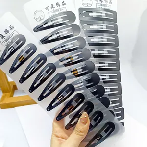 Barrettes clic-clac en métal noir mat au design goutte sur emballage en carton