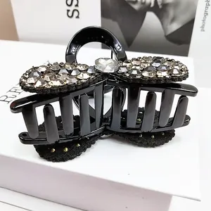 Détail macro d'une pince à cheveux noire avec nœud et ornements en strass brillants