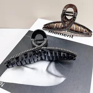Detailed view of black and amber rhinestone hair claws with glossy resin finish