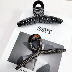 Detailed view of large rhinestone hair clips in black and amber on a magazine