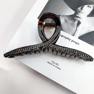 Elegant large hair claw clip with sparkling rhinestones on a stylish twist design