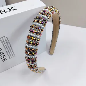 Detail of sponge headband with colorful rhinestones and white pearls on beige lining