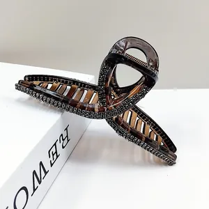 Close-up of elegant amber large hair claw clip with crystal rhinestones and metal spring