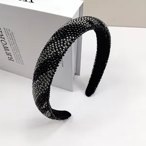 Dettaglio di un cerchietto imbottito fatto a mano con perle argentate su base nera